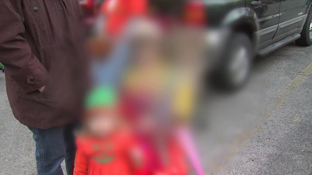 Family standing in front of a car with center of image blurred