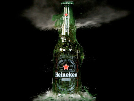 Slow motion capture of exploding Heineken beer bottle