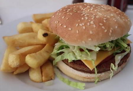 Vegan burger, lettuce and cheese in a bun with fries